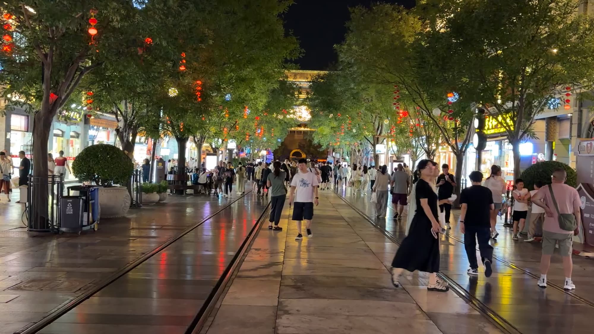 Qianmen Street at night, lanterns in the trees and tram tracks down the middle